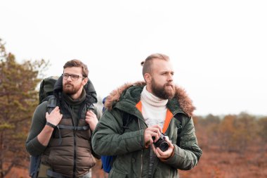Bataklık içinde yürüyüş ve fotoğraf çekmek sırt çantaları ile iki adam. Kamp, macera, seyahat ve balık tutma kavramı.