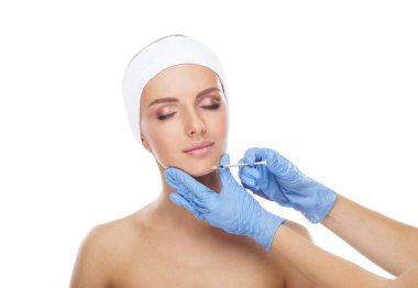 Genç bir kadının güzel yüzüne iğne yapan bir doktor. Estetik ameliyat, cilt gerdirme ve estetik tıp konsepti.