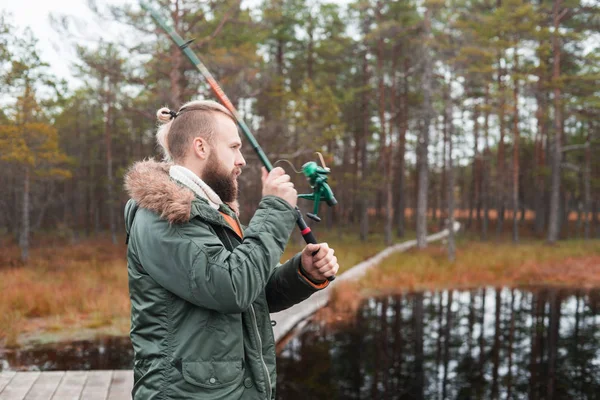 Balıkçı bir nehirde balık yakalamak bir iplik çubuk ile. Adam bir hafta sonu. Hobi, eğlence ve etkin yaz ve sonbahar kavramı. Kırsal arka plan.