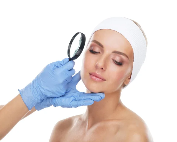若くて美しい女の子と虫眼鏡の顔 整形手術 フェイス リフト 美容医学の概念 — ストック写真