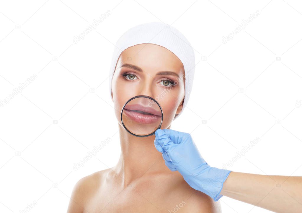 Face of young and beautiful girl and a magnifying glass. Woman with a huge lips. Plastic surgery, face lifting and aesthetic medicine concept.