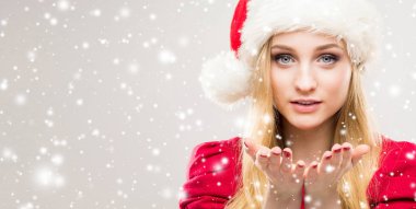 Arka plan ile kar üzerinde Noel şapkalı güzel, genç ve güzel kız. 