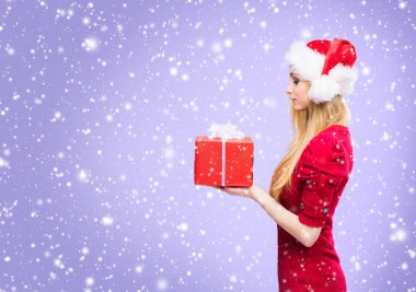 Kar taneleri ile kış arka plan üzerinde Noel şapkalı çekici ve güzel kız.