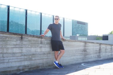 Genç ve spor giyim açık eğitim sportif adam. Yakışıklı ve formda adam sokakta. Spor, sağlık, fitness ve atletizm.