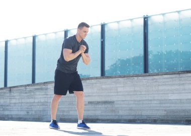 Genç ve spor giyim açık eğitim sportif adam. Yakışıklı ve formda adam sokakta. Spor, sağlık, fitness ve atletizm.