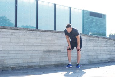 Genç ve spor giyim açık eğitim sportif adam. Yakışıklı ve formda adam sokakta. Spor, sağlık, fitness ve atletizm.