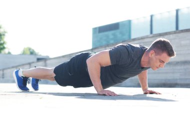 Genç ve spor giyim açık eğitim sportif adam. Yakışıklı ve formda adam sokakta. Spor, sağlık, fitness ve atletizm.