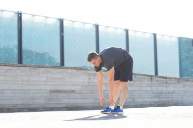 Genç ve spor giyim açık eğitim sportif adam. Yakışıklı ve formda adam sokakta. Spor, sağlık, fitness ve atletizm.