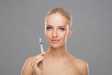 Genç bir kadının yüzüne güzellik aşısı. Estetik ameliyat, cilt gerdirme ve estetik tıp konsepti.