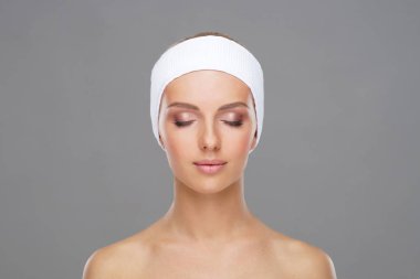 Genç ve sağlıklı kız gri arka plan üzerinde güzel yüzü. Cilt Bakımı, kozmetik ve yüz kavramı kaldırma.