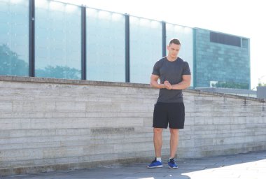 Genç ve spor giyim açık eğitim sportif adam. Yakışıklı ve formda adam sokakta. Spor, sağlık, fitness ve atletizm.