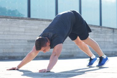 Genç ve spor giyim açık eğitim sportif adam. Yakışıklı ve formda adam sokakta. Spor, sağlık, fitness ve atletizm.