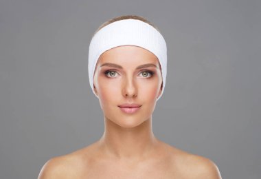 Genç ve sağlıklı kız gri arka plan üzerinde güzel yüzü. Cilt Bakımı, kozmetik ve yüz kavramı kaldırma.