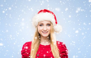 Arka plan ile kar üzerinde Noel şapkalı güzel, genç ve güzel kız. 