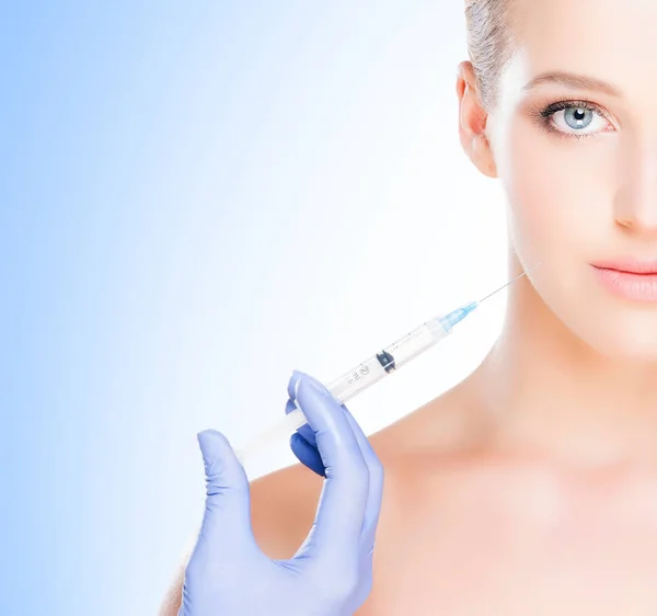 美しい 青い背景上に皮膚の注射を持って健康的な女性 整形外科のコンセプト — ストック写真