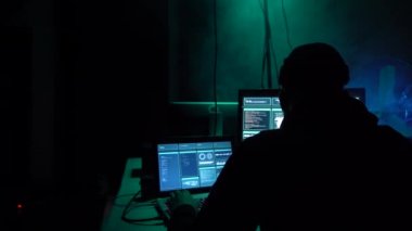 Aranan hackerlar virüs fidye yazılımını bodrumdaki bilgisayar ve dizüstü bilgisayarlarla kodluyorlar. Siber saldırı, sistem kırma ve kötü amaçlı yazılım kavramı.
