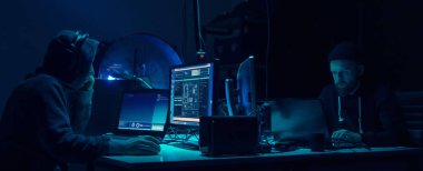 Bilgisayar ve dizüstü bilgisayar kullanarak virüs fidye virüsü kodlayan aranan hackerlar. Siber saldırı, sistem kırma ve kötü amaçlı yazılım kavramı.