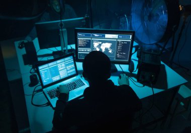 Bilgisayar ve dizüstü bilgisayar kullanarak virüs fidye virüsü kodlayan aranan hackerlar. Siber saldırı, sistem kırma ve kötü amaçlı yazılım kavramı.
