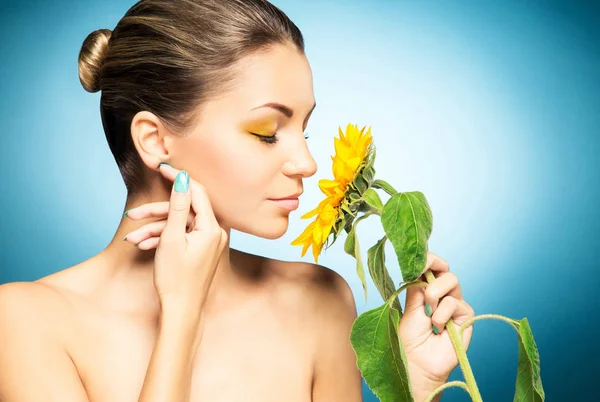 美丽的妇女的画像和黄色向日葵在蓝色背景 春天的概念 — 图库照片
