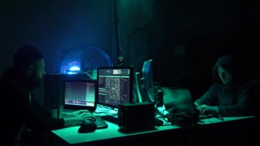 Aranan hackerlar virüs fidye yazılımını bodrumdaki bilgisayar ve dizüstü bilgisayarlarla kodluyorlar. Siber saldırı, sistem kırma ve kötü amaçlı yazılım kavramı.