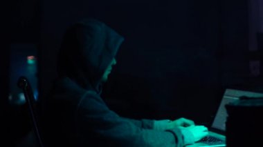 Aranan hackerlar virüs fidye yazılımını bodrumdaki bilgisayar ve dizüstü bilgisayarlarla kodluyorlar. Siber saldırı, sistem kırma ve kötü amaçlı yazılım kavramı.