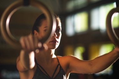 Bir spor salonunda çalışmaya uygun, sportif ve atletik sporcumuz. Jimnastik halkalar kullanarak eğitim kadın. Spor, yaşam tarzı, atletizm ve fitness kavramı.