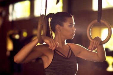 Bir spor salonunda çalışmaya uygun, sportif ve atletik sporcumuz. Jimnastik halkalar kullanarak eğitim kadın. Spor, yaşam tarzı, atletizm ve fitness kavramı.
