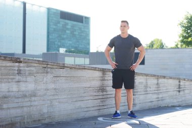 Genç ve spor giyim açık eğitim sportif adam. Yakışıklı ve formda adam sokakta. Spor, sağlık, fitness ve atletizm.