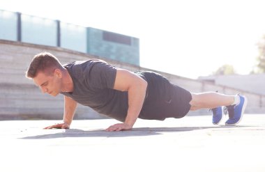 Genç ve spor giyim açık eğitim sportif adam. Yakışıklı ve formda adam sokakta. Spor, sağlık, fitness ve atletizm.