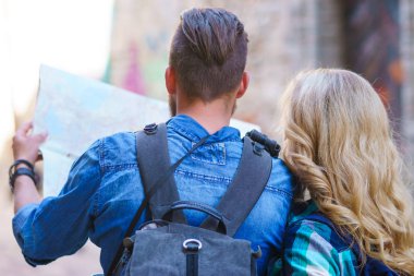 Genç gezginler yön bir turist haritası ile keşfetmek. Erkek ve kadın tatil sahip. Backpackers, seyahat ve Turizm kavramı.