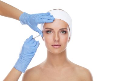 Genç bir kadının güzel yüzüne iğne yapan bir doktor. Estetik ameliyat, cilt gerdirme ve estetik tıp konsepti.