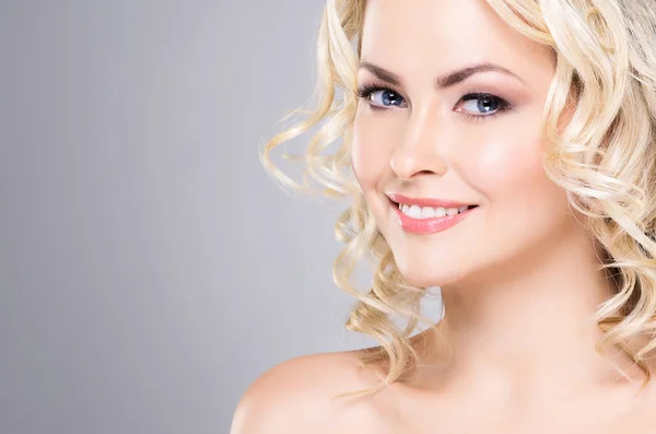 Retrato de una joven y hermosa rubia con el pelo rizado. Concepto de lifting facial y belleza . — Foto de Stock