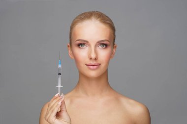 Genç bir kadının yüzüne güzellik aşısı. Estetik ameliyat, cilt gerdirme ve estetik tıp konsepti.