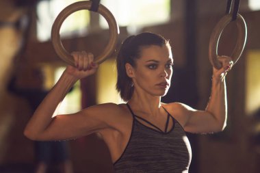 Bir spor salonunda çalışmaya uygun, sportif ve atletik sporcumuz. Jimnastik halkalar kullanarak eğitim kadın. Spor, yaşam tarzı, atletizm ve fitness kavramı.
