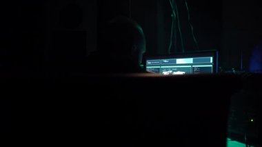 Aranan hackerlar virüs fidye yazılımını bodrumdaki bilgisayar ve dizüstü bilgisayarlarla kodluyorlar. Siber saldırı, sistem kırma ve kötü amaçlı yazılım kavramı.