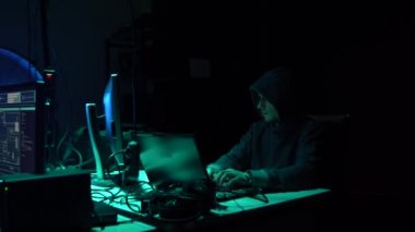 Aranan hackerlar virüs fidye yazılımını bodrumdaki bilgisayar ve dizüstü bilgisayarlarla kodluyorlar. Siber saldırı, sistem kırma ve kötü amaçlı yazılım kavramı.