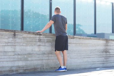 Genç ve spor giyim açık eğitim sportif adam. Yakışıklı ve formda adam sokakta. Spor, sağlık, fitness ve atletizm.