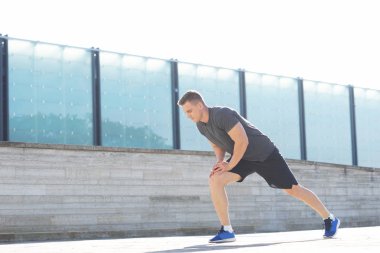 Genç ve spor giyim açık eğitim sportif adam. Yakışıklı ve formda adam sokakta. Spor, sağlık, fitness ve atletizm.