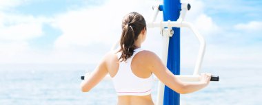 Spor ve fitness kavramı. Genç, uygun ve açık bir spor salonunda çalışan sportif kadın.