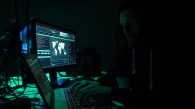 Aranan hackerlar virüs fidye yazılımını bodrumdaki bilgisayar ve dizüstü bilgisayarlarla kodluyorlar. Siber saldırı, sistem kırma ve kötü amaçlı yazılım kavramı.