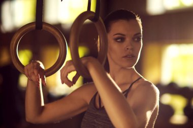 Bir spor salonunda çalışmaya uygun, sportif ve atletik sporcumuz. Jimnastik halkalar kullanarak eğitim kadın. Spor, yaşam tarzı, atletizm ve fitness kavramı.