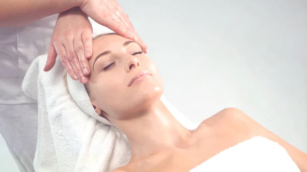 Young attractive woman getting spa treatment over white background. — Stock Photo, Image