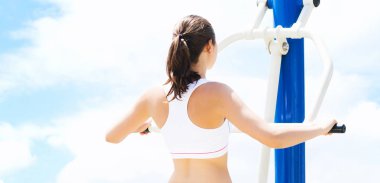 Spor ve fitness kavramı. Genç, uygun ve açık bir spor salonunda çalışan sportif kadın.