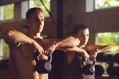 Ağırlıklar ile egzersiz yaparak kadın ve erkek. Bir spor salonunda eğitim vücut geliştiriciler.