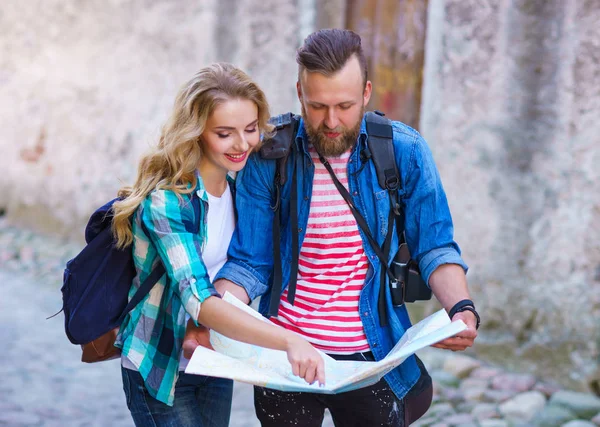 Jonge reizigers met een toeristische kaart. Man en vrouw met vakantie. Backpackers, reizen en toerisme concept. — Stockfoto