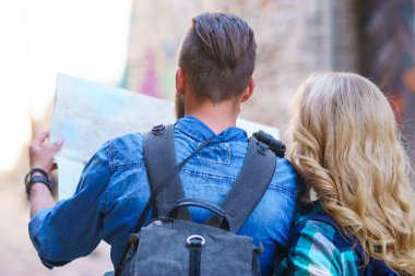 Genç gezginler yön bir turist haritası ile keşfetmek. Erkek ve kadın tatil sahip. Backpackers, seyahat ve Turizm kavramı.