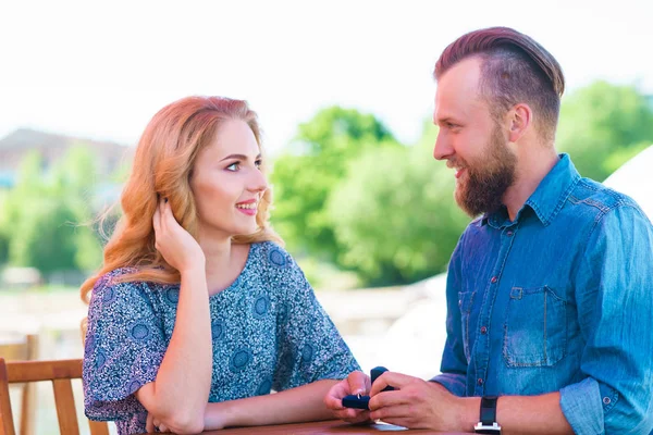 Marry me concept. Loving couple getting engaged in an outdoor cafe. Man making proposal to his girlfriend.