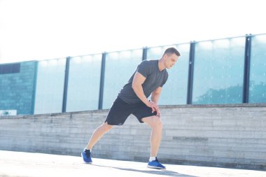 Genç ve spor giyim açık eğitim sportif adam. Yakışıklı ve formda adam sokakta. Spor, sağlık, fitness ve atletizm.