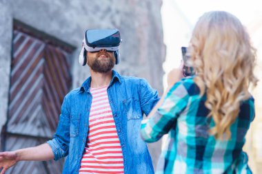 Artar veya sanal gerçeklik kulaklık sokakta yürüyen bir çift. VR, Ar, eğlence cihazları ve fütüristik teknoloji kavramı.