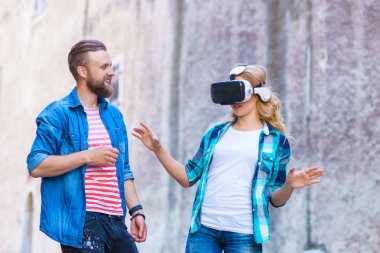Artar veya sanal gerçeklik kulaklık sokakta yürüyen bir çift. VR, Ar, eğlence cihazları ve fütüristik teknoloji kavramı.